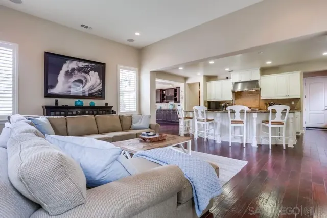 a living room with furniture kitchen and a wooden floor