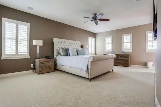 a spacious bedroom with a bed a chandelier and a window