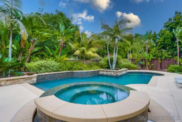 a view of a swimming pool with a yard and plants