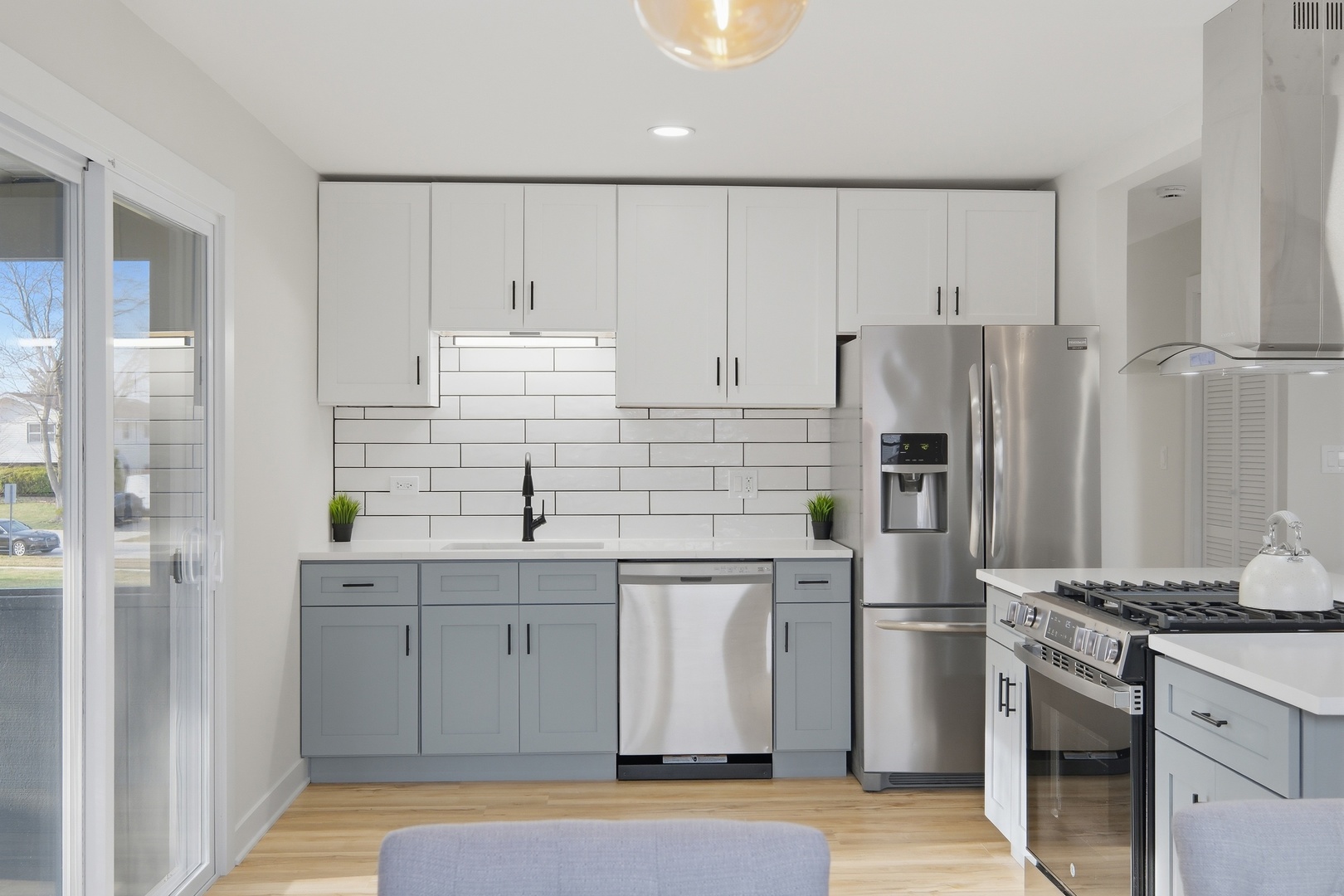 1450 Meyer Road Hoffman Estates, IL 60169 - Photo 7 of 28 a kitchen with white cabinets and stainless steel appliances