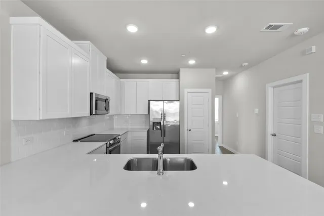 a kitchen with stainless steel appliances a sink and cabinets