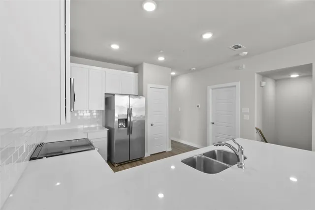 a kitchen with a refrigerator and a sink