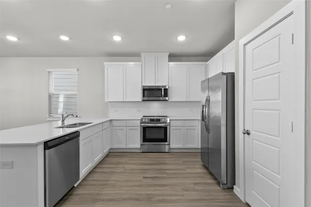 a kitchen with stainless steel appliances granite countertop a refrigerator and a stove top oven