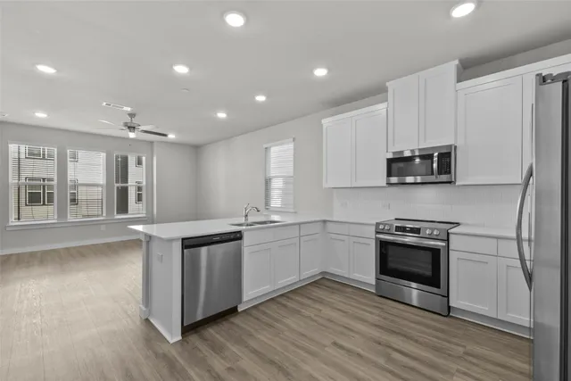 a kitchen with stainless steel appliances granite countertop a stove a sink and a refrigerator