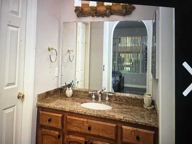 a bathroom with a granite countertop sink and a mirror