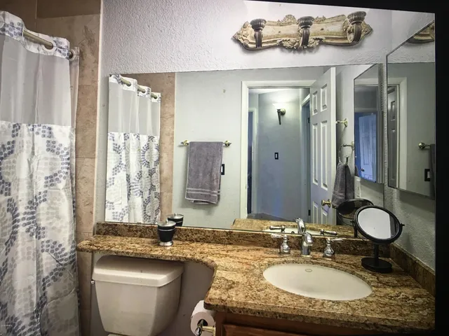 a bathroom with a granite countertop sink and a mirror