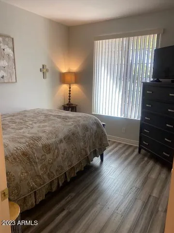 a bedroom with a bed and a flat tv screen on dresser