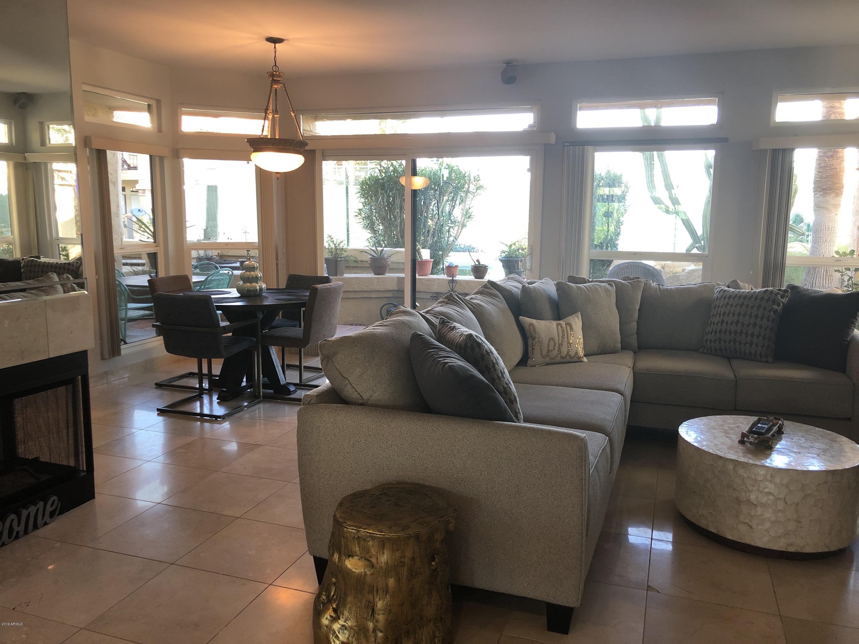 9707 East Mountain View Road, Unit 1414 Scottsdale, AZ 85258 - Photo 2 of 40 a living room with furniture and a large window