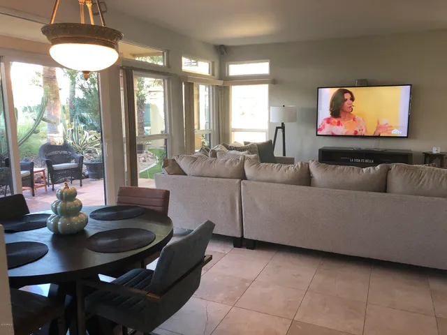a living room with furniture a flat screen tv and a large window
