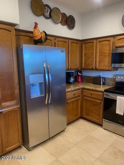 9707 East Mountain View Road, Unit 1414 Scottsdale, AZ 85258 - Photo 8 of 40 a kitchen with a refrigerator and a stove