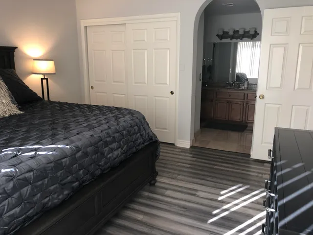 a bedroom with a bed and wooden floor