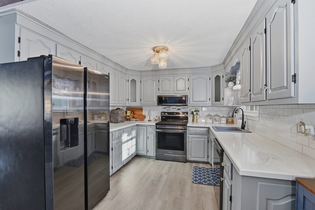 80 Walnut Street Middleboro, MA 02346 - Photo 11 of 34 a kitchen with stainless steel appliances granite countertop a refrigerator a stove a sink dishwasher and a refrigerator with wooden cabinets