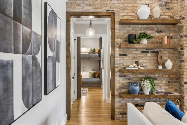 a spacious bedroom with a bed a chandelier and large window