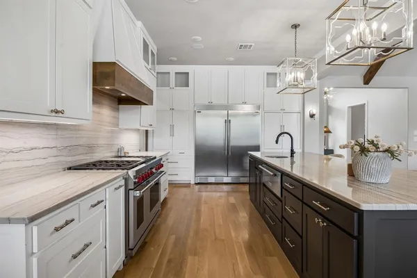 a kitchen with kitchen island granite countertop a stove and a sink