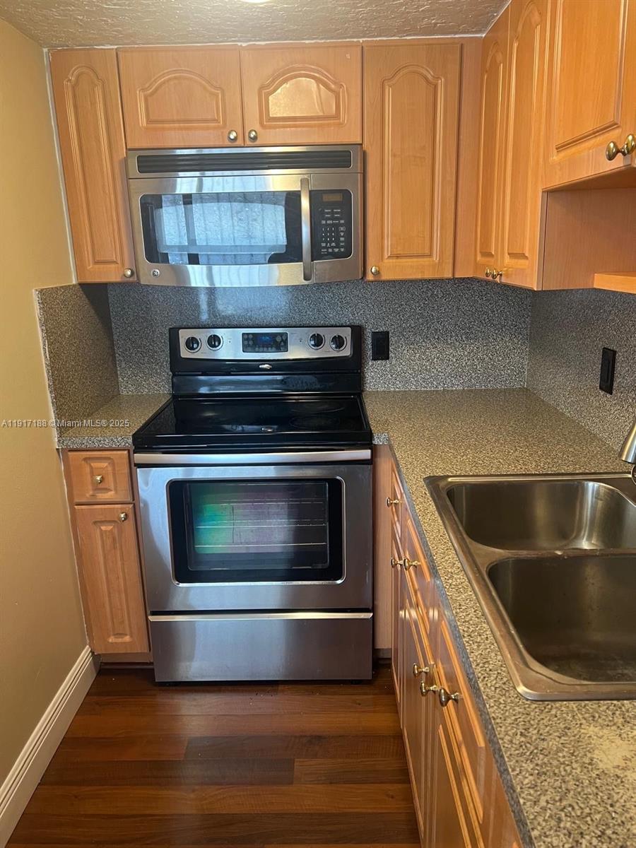 5306 West 26th Avenue, Unit 102 Hialeah, FL 33016 - Photo 16 of 33 a kitchen with granite countertop a stove and a sink
