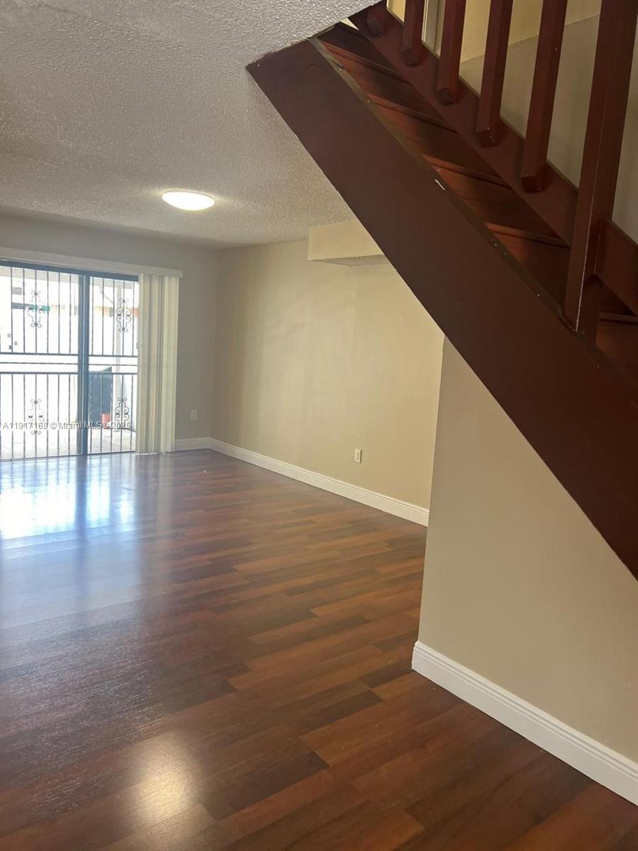 5306 West 26th Avenue, Unit 102 Hialeah, FL 33016 - Photo 17 of 33 a view of an empty room with wooden floor and a window