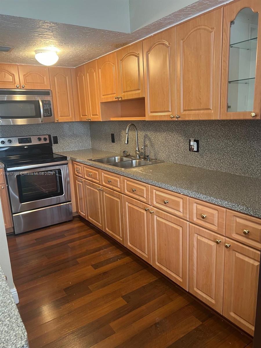 5306 West 26th Avenue, Unit 102 Hialeah, FL 33016 - Photo 18 of 33 a kitchen with granite countertop a sink and cabinets