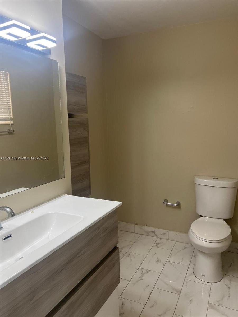 5306 West 26th Avenue, Unit 102 Hialeah, FL 33016 - Photo 2 of 33 a bathroom with a toilet and a sink