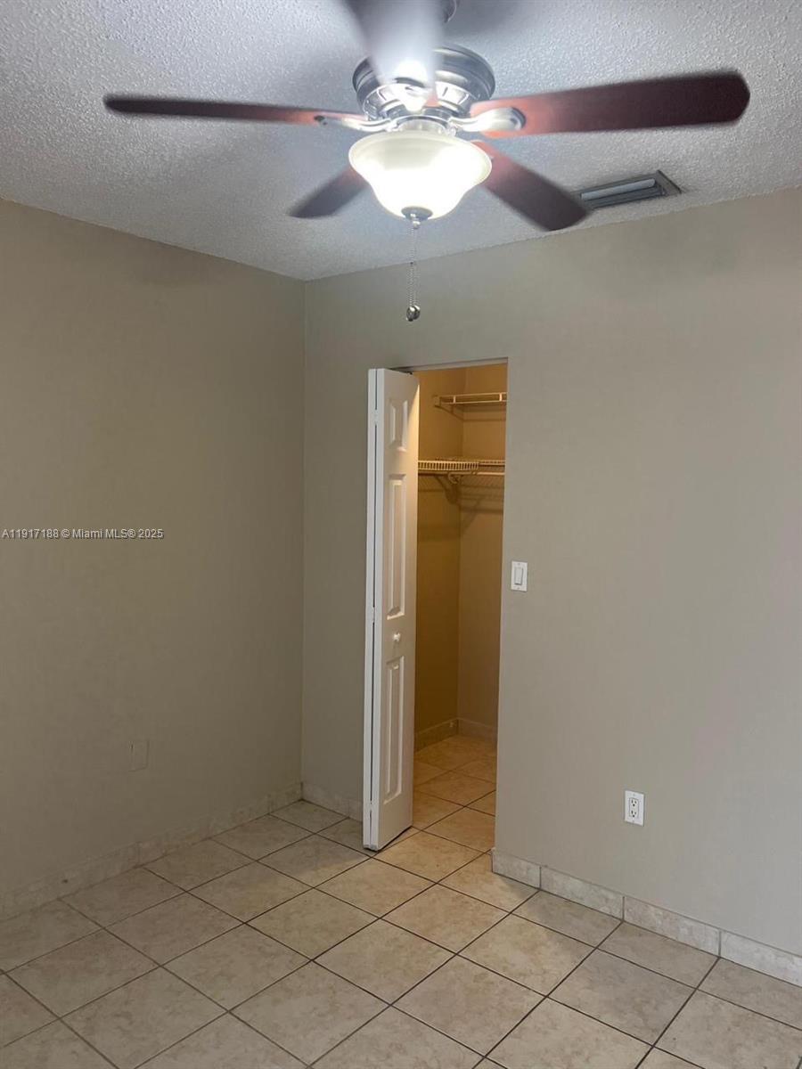 5306 West 26th Avenue, Unit 102 Hialeah, FL 33016 - Photo 22 of 33 an empty room with a ceiling fan and a window