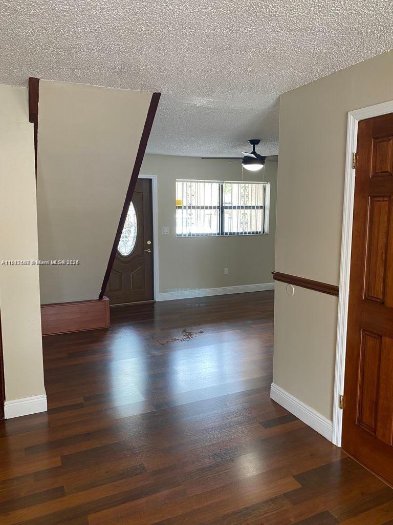5306 West 26th Avenue, Unit 102 Hialeah, FL 33016 - Photo 30 of 33 an empty room with wooden floor and windows