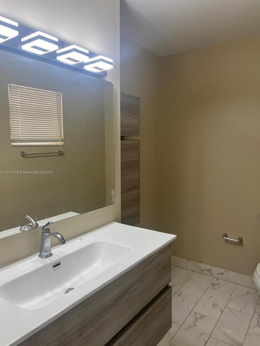 5306 West 26th Avenue, Unit 102 Hialeah, FL 33016 - Photo 6 of 33 a bathroom with a sink and a mirror