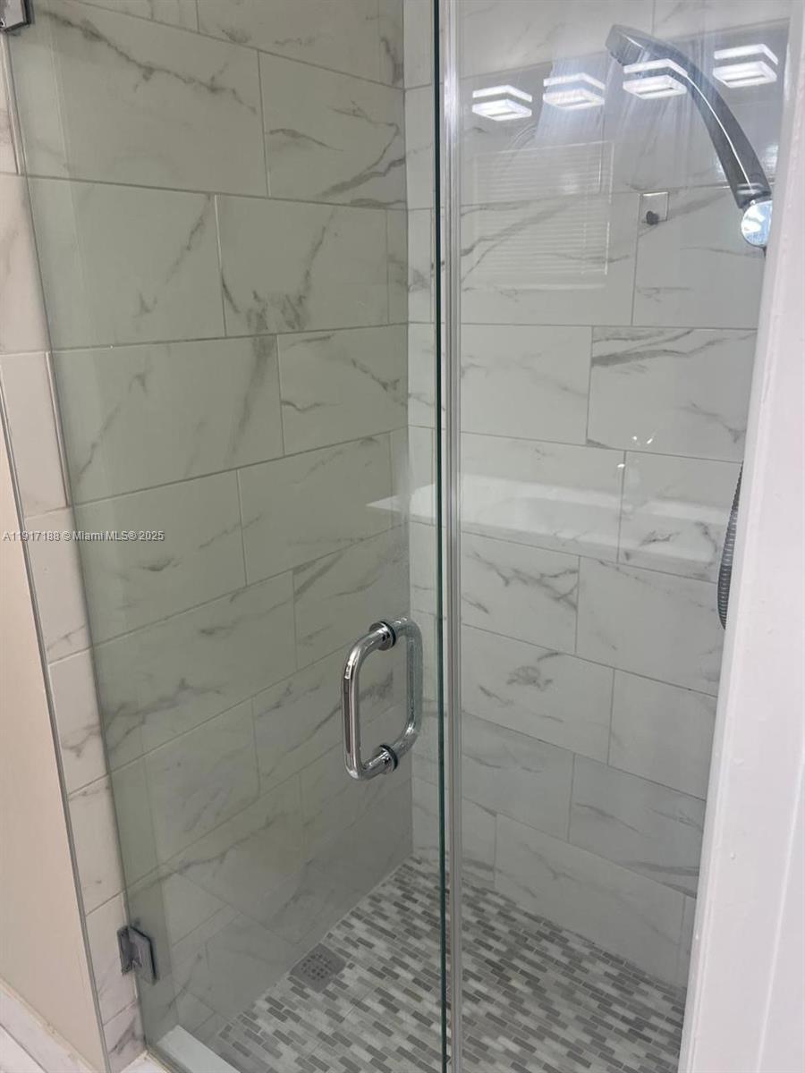 5306 West 26th Avenue, Unit 102 Hialeah, FL 33016 - Photo 7 of 33 a bathroom with a glass door shower
