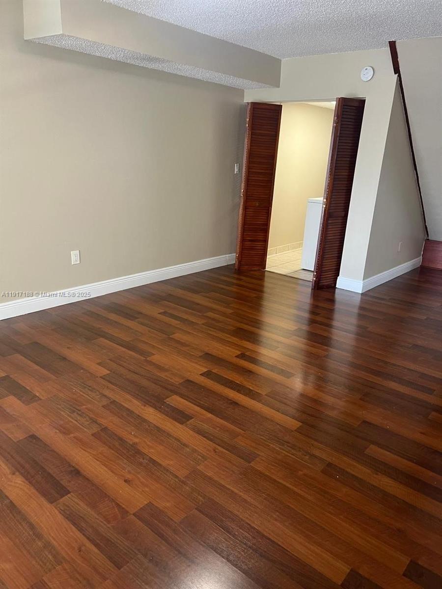 5306 West 26th Avenue, Unit 102 Hialeah, FL 33016 - Photo 10 of 33 a view of an empty room with wooden floor and stairs