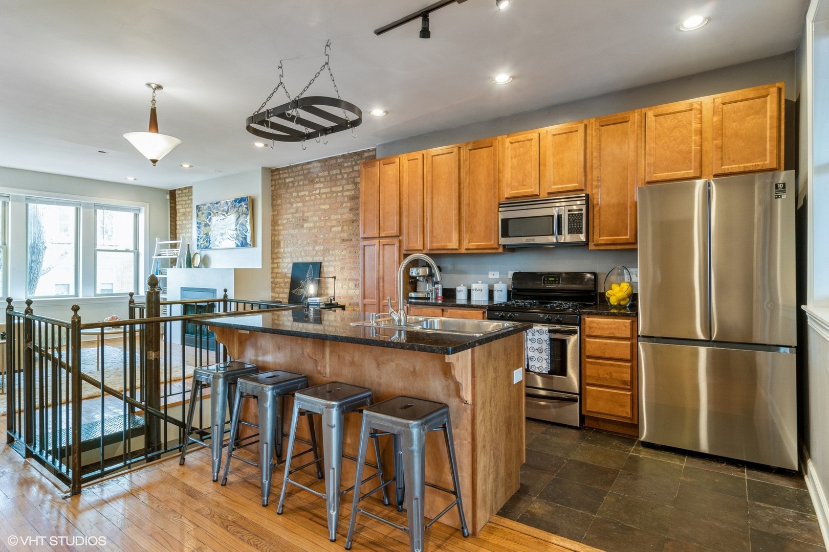 3105 West George Street, Unit 1 Chicago, IL 60618 - Photo 5 of 11 a kitchen with stainless steel appliances granite countertop a stove a refrigerator a kitchen island a stove and a refrigerator with wooden floor