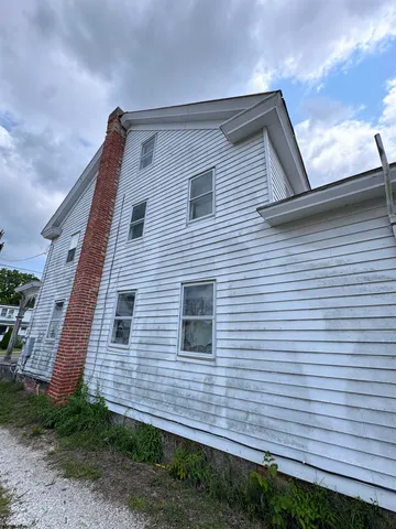 a large white house with a big yard and large trees