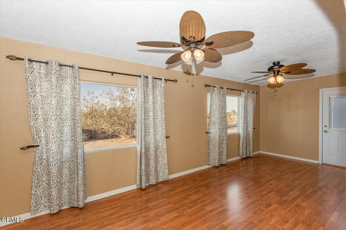 1728 Del Rosa Road Pinon Hills, CA 92372 - Photo 9 of 17 a view of a livingroom with wooden floor and a ceiling fan
