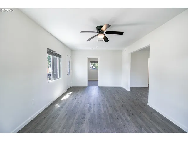 a view of empty room with wooden floor