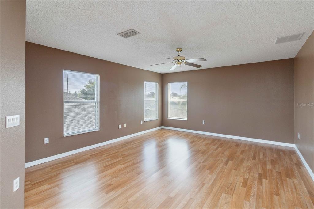 2881 Lyndscape Street Orlando, FL 32833 - Photo 11 of 30 a view of an empty room with a window and wooden floor