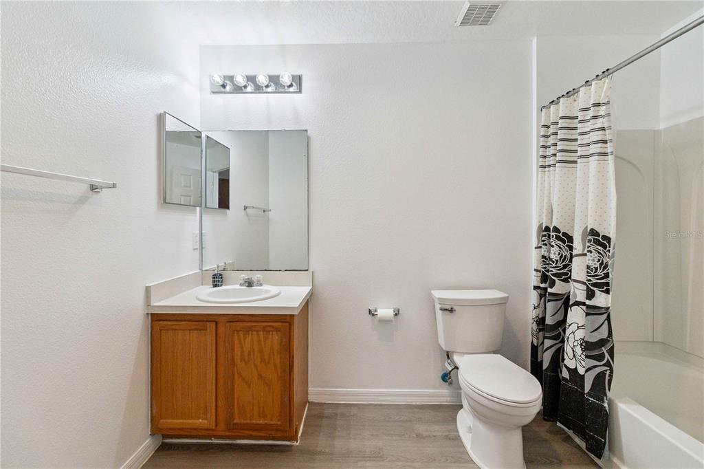 2881 Lyndscape Street Orlando, FL 32833 - Photo 20 of 30 a bathroom with a toilet sink and shower curtain