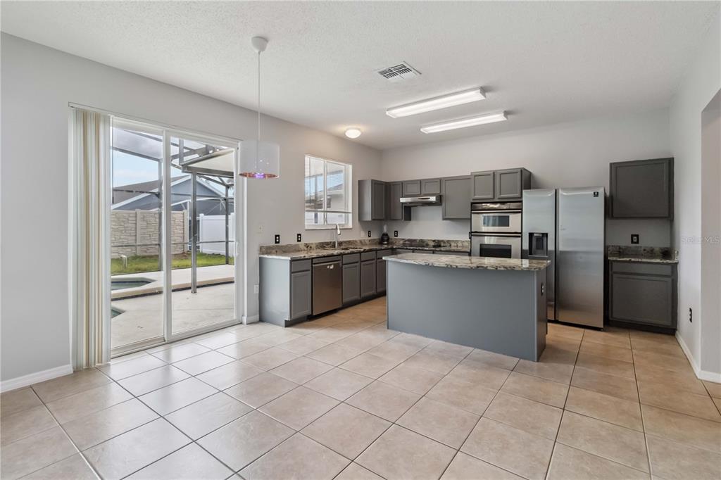 2881 Lyndscape Street Orlando, FL 32833 - Photo 6 of 30 a kitchen with stainless steel appliances a refrigerator sink and cabinets