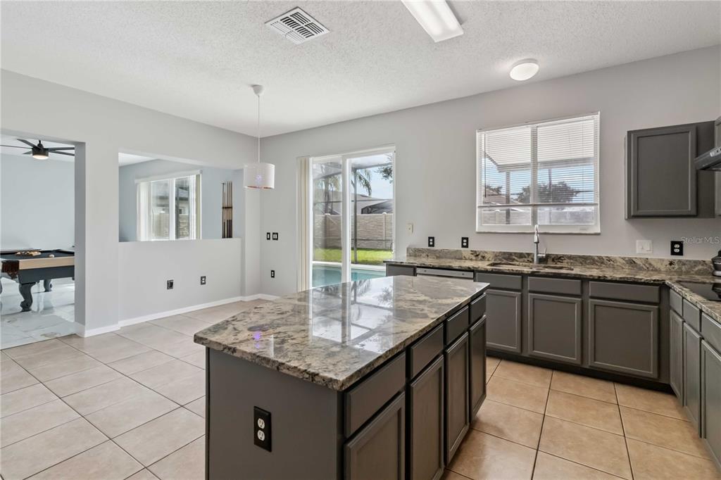 2881 Lyndscape Street Orlando, FL 32833 - Photo 7 of 30 a kitchen with granite countertop a sink and a stove