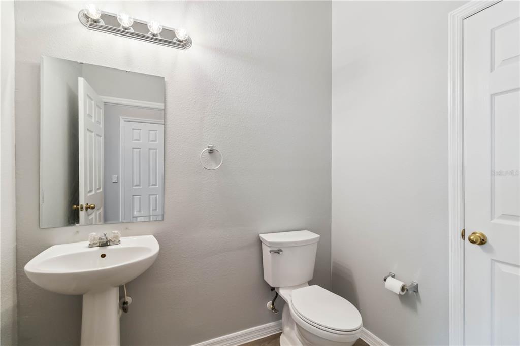 2881 Lyndscape Street Orlando, FL 32833 - Photo 9 of 30 a bathroom with a toilet sink and mirror