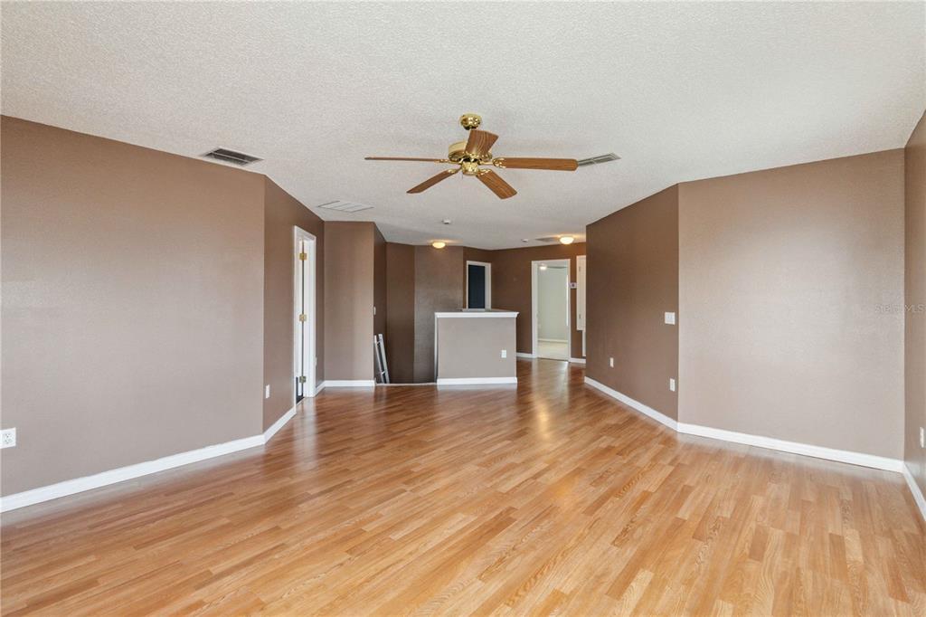 2881 Lyndscape Street Orlando, FL 32833 - Photo 10 of 30 a view of a livingroom with a chandelier fan and wooden floor