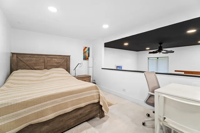 a bedroom with a white bed and a flat screen tv