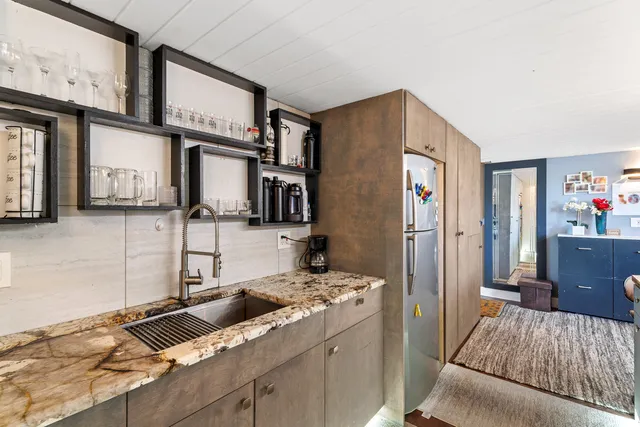 a kitchen with stainless steel appliances granite countertop a sink stove and refrigerator
