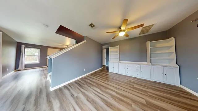 a view of empty room with wooden floor