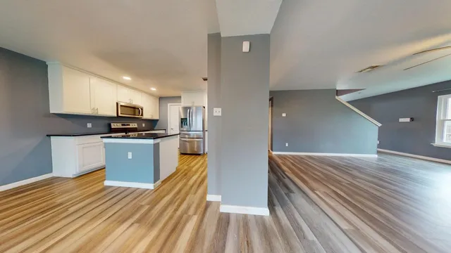 a kitchen with wooden floors and refrigerator