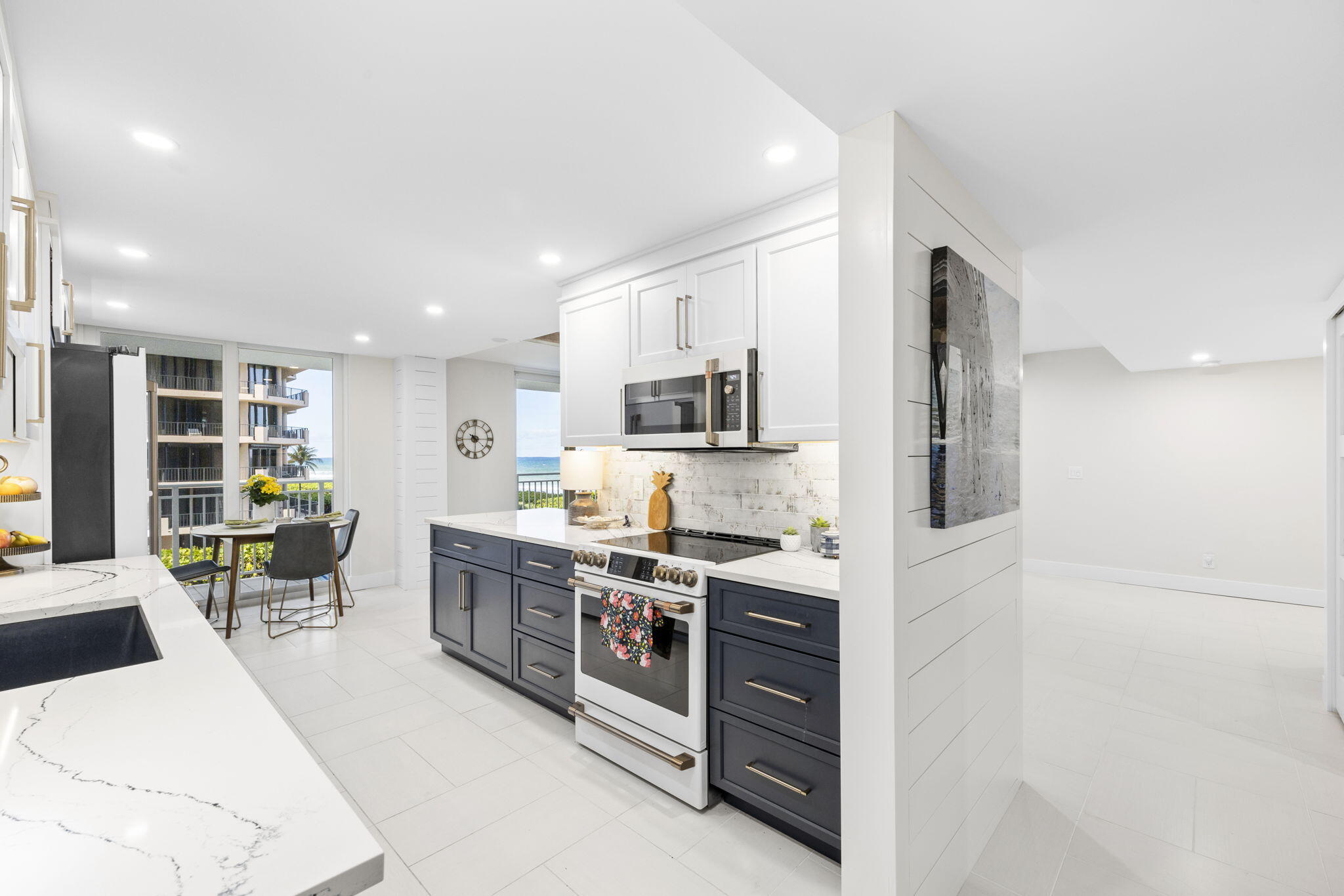 500 Ocean Drive, Unit E3A Juno Beach, FL 33408 - Photo 11 of 28 a large white kitchen with stainless steel appliances granite countertop a stove and a sink