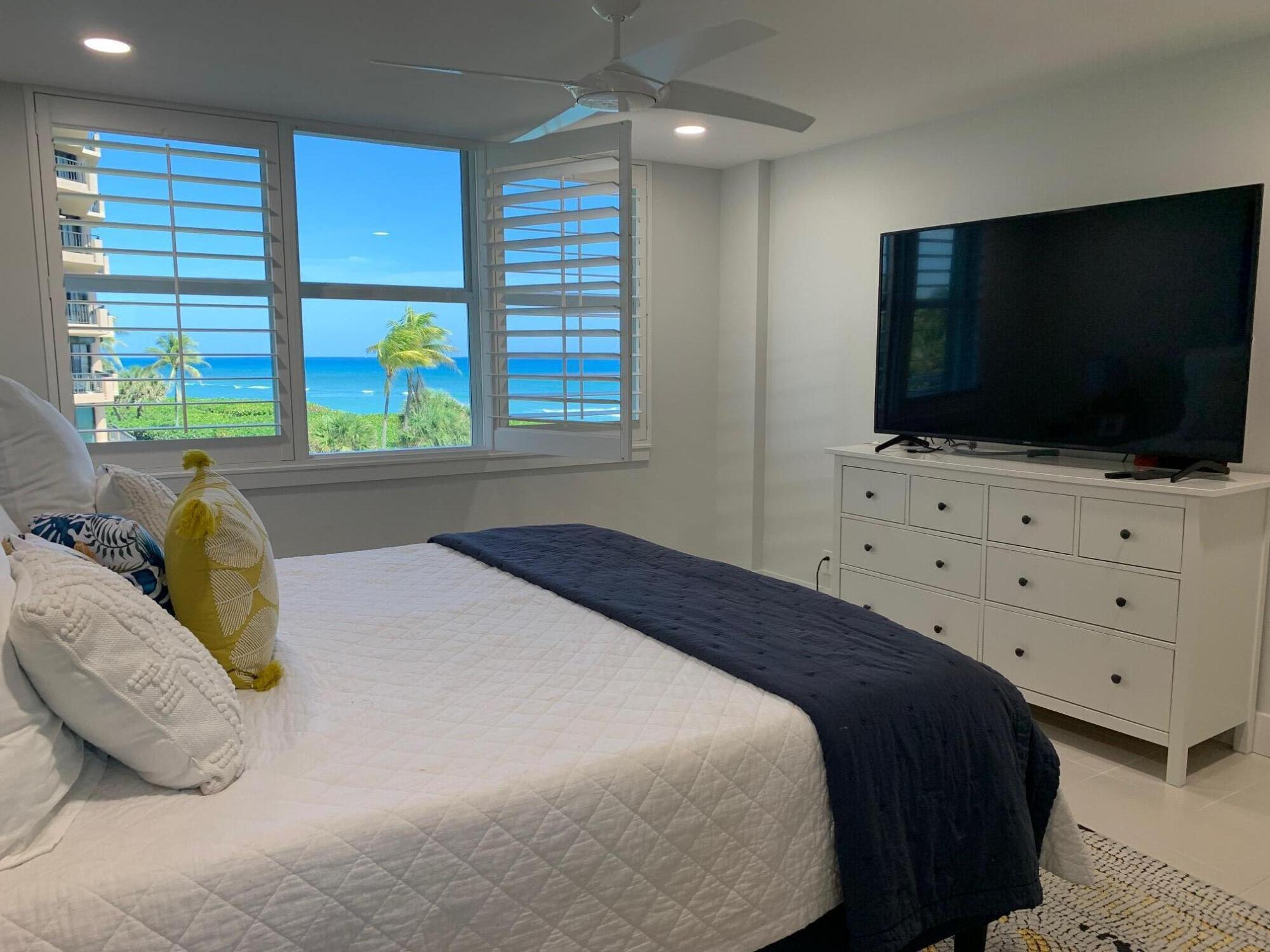 500 Ocean Drive, Unit E3A Juno Beach, FL 33408 - Photo 19 of 28 a bedroom with a bed and a flat screen tv