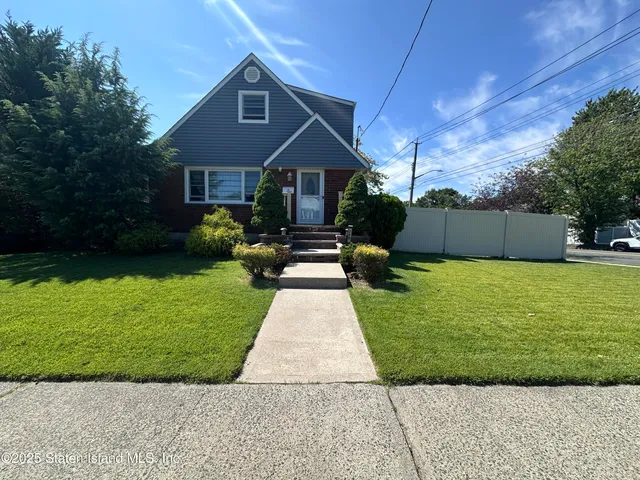 a front view of a house with a yard and trees