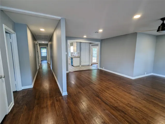 a view of a hallway with wooden floor and glass door