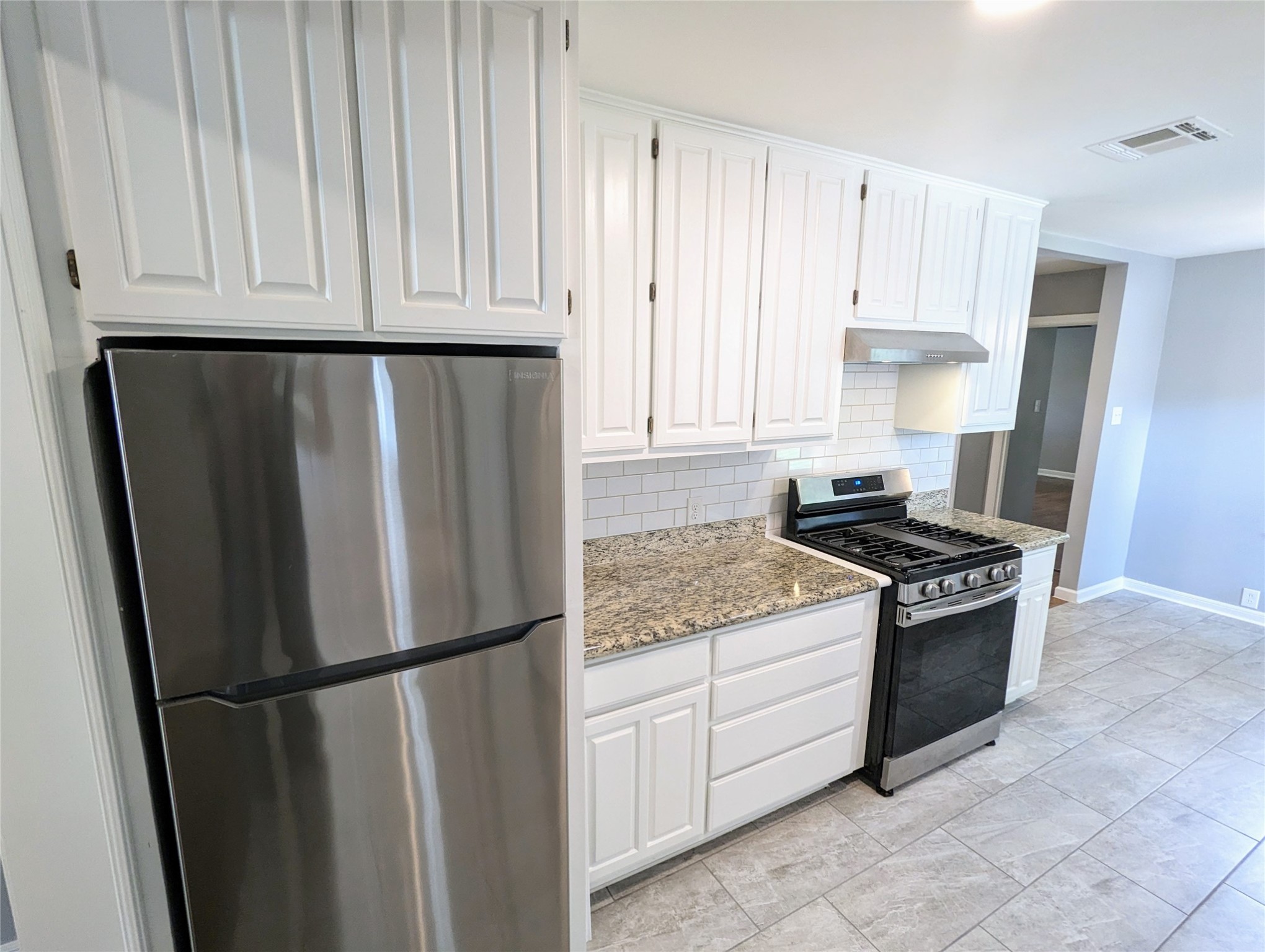 3111 Deal Street Houston, TX 77025 - Photo 14 of 39 a kitchen with stainless steel appliances granite countertop a refrigerator a stove and white cabinets