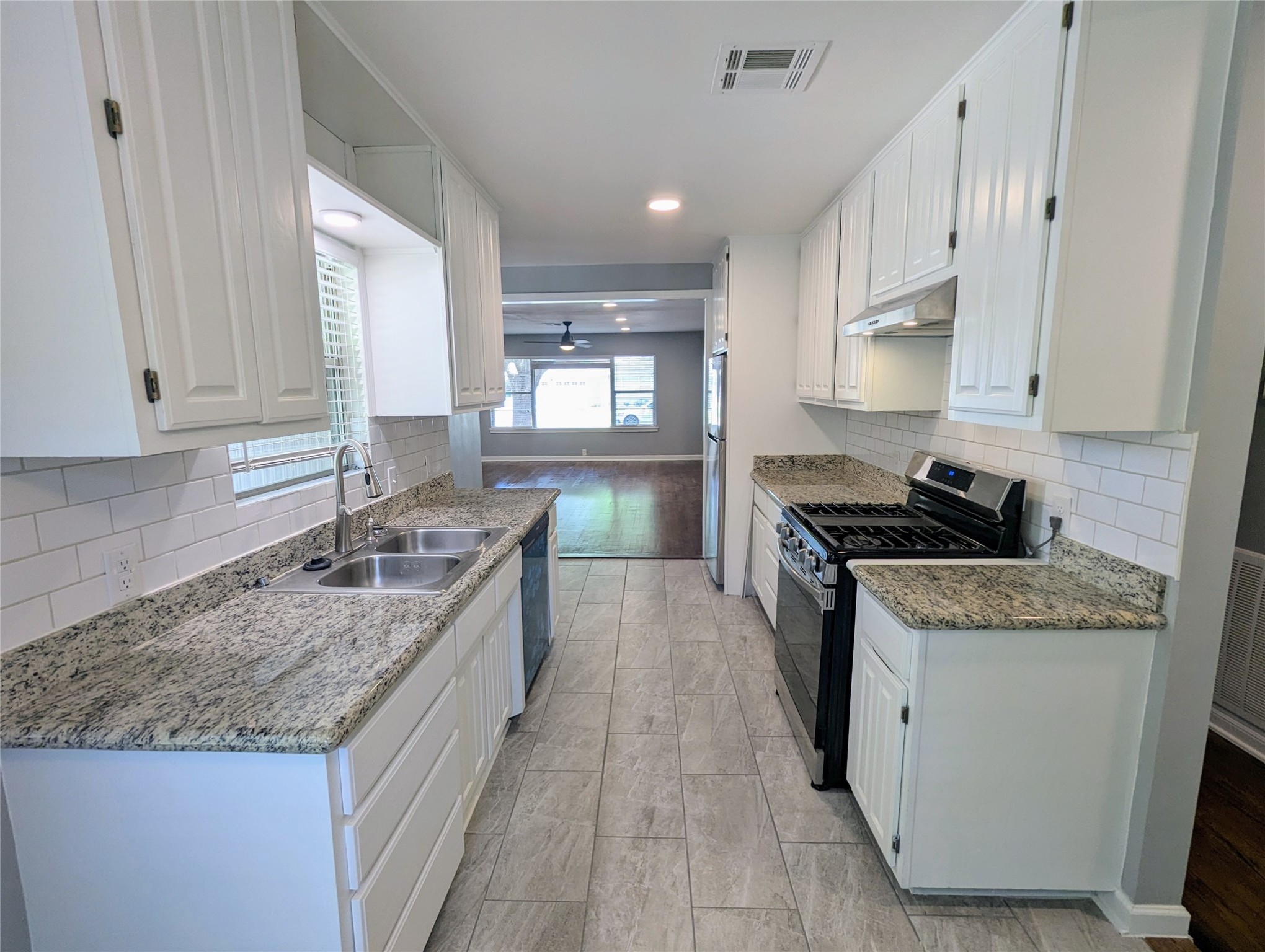 3111 Deal Street Houston, TX 77025 - Photo 17 of 39 a kitchen with granite countertop kitchen island a sink a counter top space and cabinets