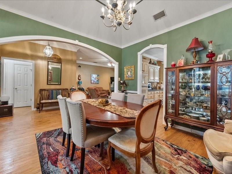 1704 South Bowen Road Pantego, TX 76013 - Photo 5 of 37 Formal dining area-(furniture not provided with rental) featuring wood-finish flooring, a vaulted ceiling with crown molding, and an ornate chandelier