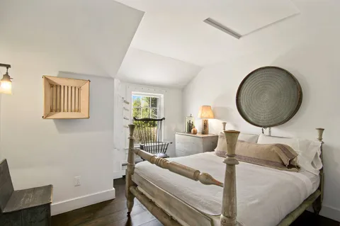 a living room with furniture a mirror and a wooden floor