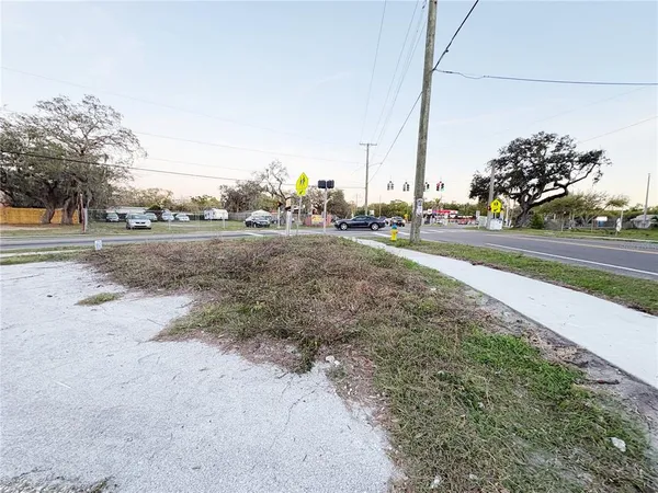 a view of a yard with cars on road